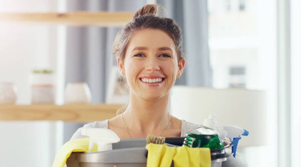 Did you know that a clean house elevates your mood. Closeup shot of a young woman holding a bucket with cleaning supplies at home - Foto, Bild