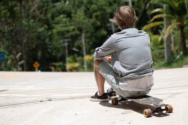 Young adult man with skate board on the road. High quality photo - Foto, Bild
