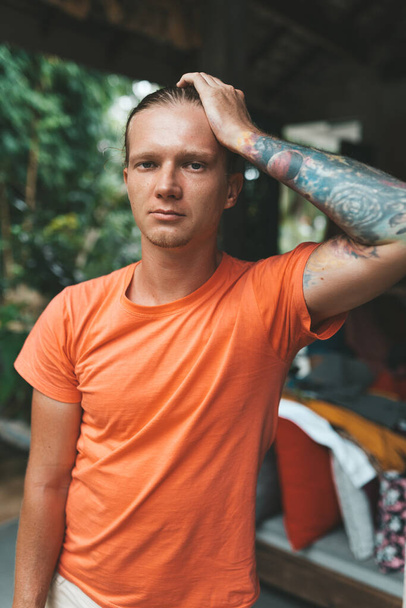Portrait of blonde man in orange t-shirt. High quality photo - Foto, imagen