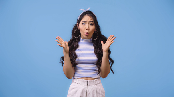 scioccato e giovane donna asiatica con la bocca aperta gesticolando isolato su blu  - Foto, immagini