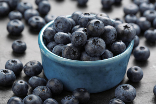 Tasty fresh blueberries on grey table, closeup - Foto, Imagen