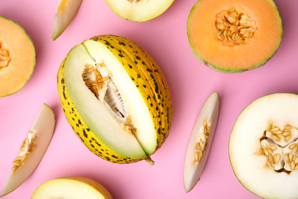 Tasty colorful ripe melons on pink background, flat lay - Photo, image