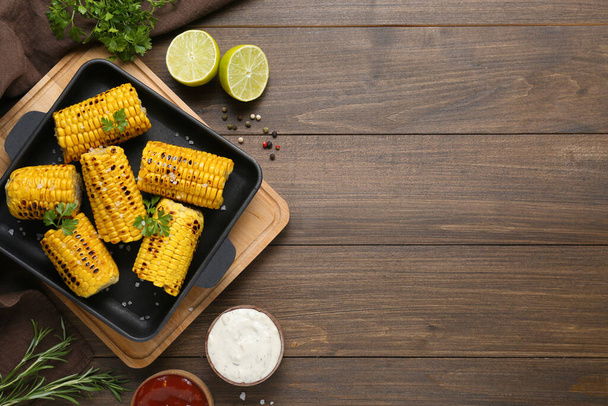 Flat lay composition with tasty grilled corn on wooden table. Space for text - Foto, Imagem