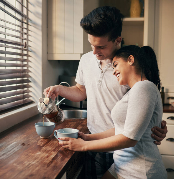 Tomemos un café y volvamos a la cama. una joven pareja vertiendo su café de la mañana - Foto, imagen