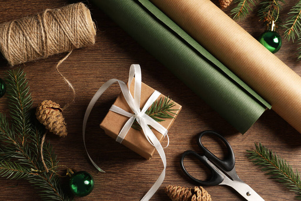 Composición plana con hermosa caja de regalo y decoraciones en mesa de madera. Regalo de Navidad - Foto, Imagen