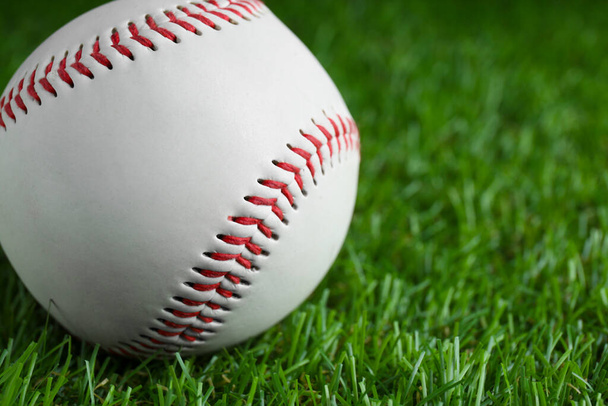Baseball ball on green grass, closeup with space for text. Sports game - 写真・画像