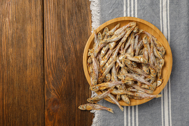 Tasty dried anchovies on wooden table, top view. Space for text - Valokuva, kuva
