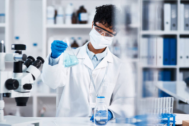 Podría hacer algunos avances nuevos hoy. un joven científico sosteniendo un vaso de precipitados en un laboratorio - Foto, Imagen