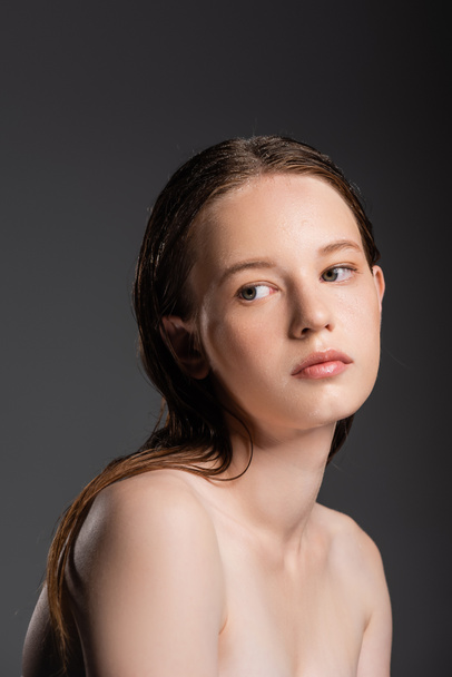 Young woman with wet hair and naked shoulders looking away isolated on grey  - Fotoğraf, Görsel