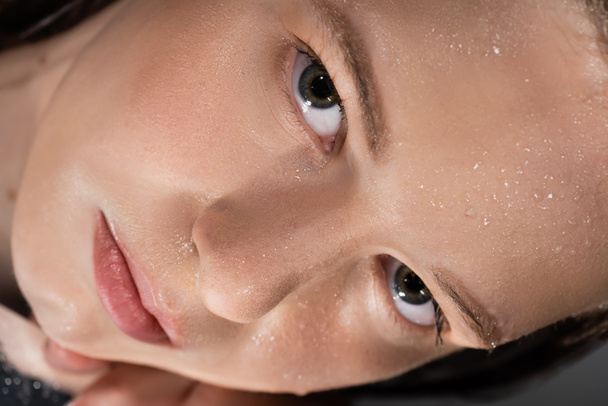 Islak yüzlü genç bir kadının aynada yatışının yakın görüntüsü.  - Fotoğraf, Görsel