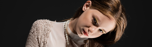 Young woman with makeup and pearl necklace looking at camera isolated on black, banner   - Foto, Imagen