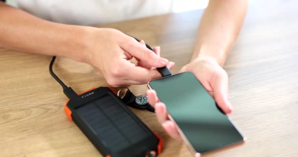 Power bank op zonne-batterijen laadt smartphone via usb-kabel. Concept van moderne gadgets en hernieuwbare energie - Video