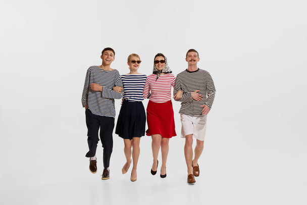 Group of four children young people, man and woman cheerfully walking isolated over white background. Concept of summer holidays, occupation, retro fashion, vintage style. Copy space for ad - Photo, Image