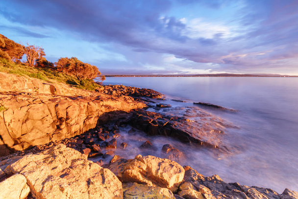Вид на утреннее восходящее солнце над опасностями полуострова Фрейсине из Суонси, Тасмания Австралия - Фото, изображение
