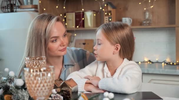 Mom and her daughter spend time together in decorated glowing lights house kitchen, talking, mother listen her kid at home enjoy winter holidays celebrate Christmas, New Year, warm relations, family - Footage, Video