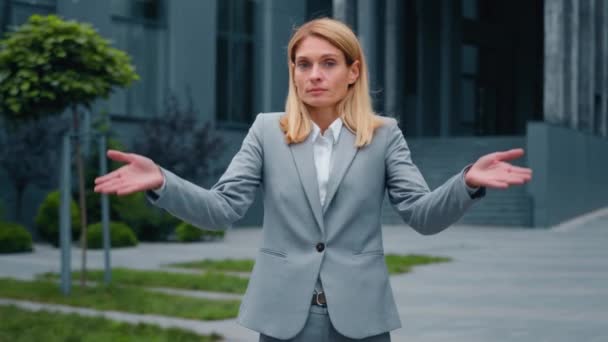 Μπερδεμένη σοβαρή σκεπτική προβληματισμένη επιχειρηματίας στέκεται σε εξωτερικούς χώρους απλώνει τα χέρια shiles αβέβαιο καυκάσιος γυναίκα doesn apos? T γνωρίζουν απάντηση κοιτάζει κάμερα δείχνει άγνοια σημάδι χειρονομία αμφιβολία shrugging ώμους - Πλάνα, βίντεο