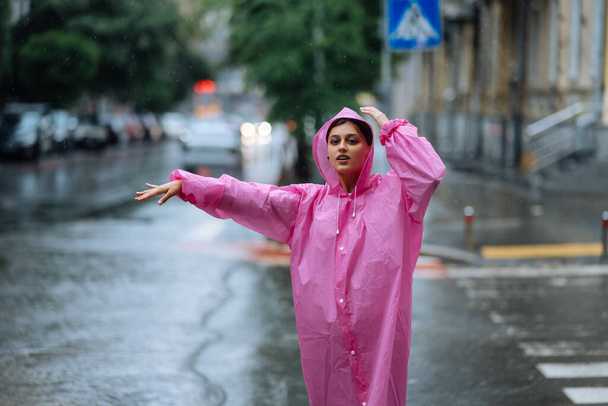 Woman catching taxi. Young girl trying to stop a cab. Woman calling a taxi on a rainy day. - Фото, изображение