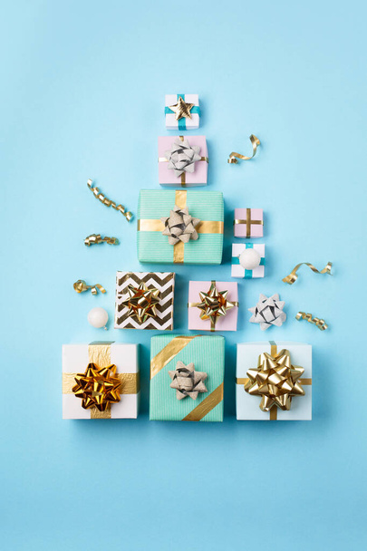 Christmas festive card. Gold and silver decorations, gifts on pastel blue paper background. Christmas, winter, new year concept. Flat lay, top view, copy space. - 写真・画像