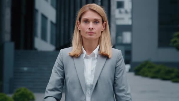 Detailní sebevědomí úspěšný mladý businesswoman ve formálním obleku pózování se zkříženými pažemi venku s úsměvem ambiciózní nezávislá žena vůdce profesionální manažer při pohledu na kameru stojící na ulici - Záběry, video