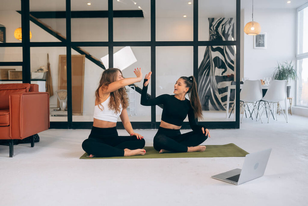 Дві молоді жінки, що медитують у позі лотоса. Йога
 - Фото, зображення