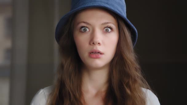 Close-up young frightened surprised woman standing indoors with wide open eyes and mouth in fright scared girl shocked by bad unbelievable news excited caucasian female student fears does not believe - Footage, Video