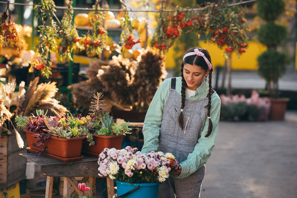 Vente de fleurs place des fleurs dans un seau à vendre sur le marché. - Photo, image