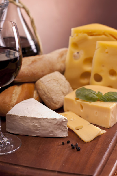 Cheese, wine and other tasty stuff on wooden table - Foto, imagen