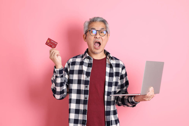 The 40s adult Asian man stnading on the pink background with casual clothes. - Foto, Imagen