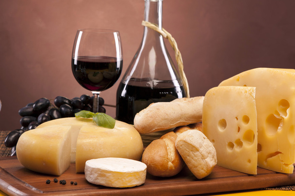 Cheese, wine and other tasty stuff on wooden table - Photo, Image