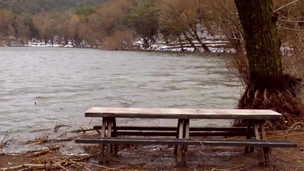 Drewniana ława siedzenia w pobliżu jeziora - Materiał filmowy, wideo