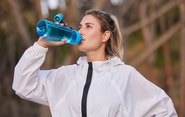 Fitness, zdrowie i biegacz kobieta z butelką wody do przerwy nawilżającej na cardio uruchomić w przyrodzie. Trening, bieganie i zdrowy tryb życia sportowca dziewczyna z napojem do treningu, ćwiczeń i sportu - Zdjęcie, obraz
