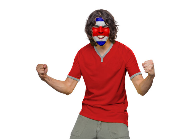 Soccer fan man with jersey and face painted with the flag of the Costa Rica team screaming with emotion on white background. - Foto, afbeelding