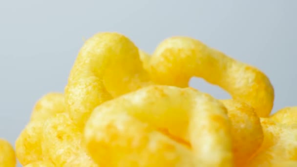 Deliziose patatine croccanti di mais con spezie girano in cerchio su uno sfondo bianco - Filmati, video