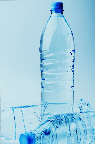 drie flessen van het water op een achtergrond met kleurovergang - Foto, afbeelding