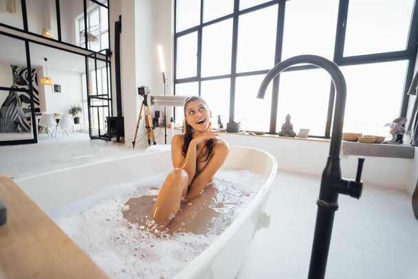 Красива молода жінка приймає ванну вдома
 - Фото, зображення