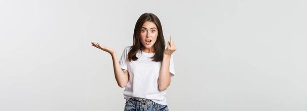 Confused and pissed-off brunette girl arguing about wedding, showing finger without ring. - Photo, Image
