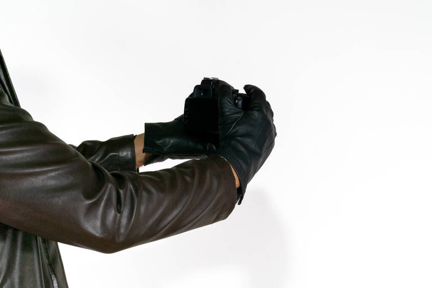 Male taking photo and show a  with black leather glove. A men spy show camera white background isolated. Creative secret agent photo view on dslr camera.  - Фото, изображение