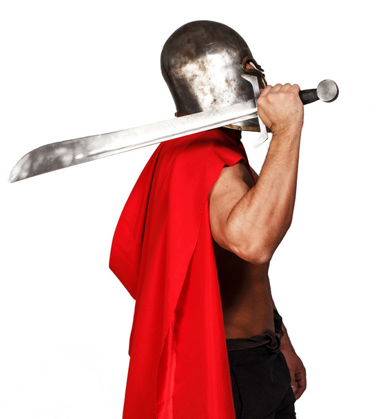 Vista lateral del guerrero sin camisa que sostiene su espada
 - Foto, imagen