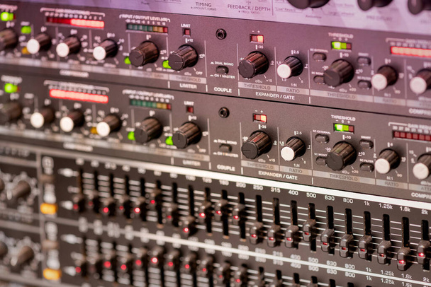Enfoque suave de muchos interruptores y palancas diferentes de amplificador de música profesional en el estudio de grabación - Foto, imagen