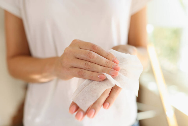 Κοντινό πλάνο γυναίκας που σκουπίζει τα χέρια χρησιμοποιώντας αντιβακτηριακά υγρά μαντηλάκια. Υγιεινή και προστασία από την έννοια covid-19 - Φωτογραφία, εικόνα