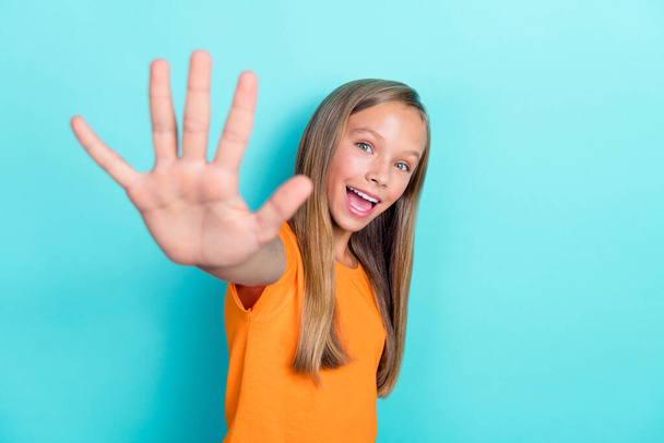 Photo of young funny attractive positive schoolkid girl wear orange t-shirt showing palm numbers five excited isolated on aquamarine color background. - Foto, Bild