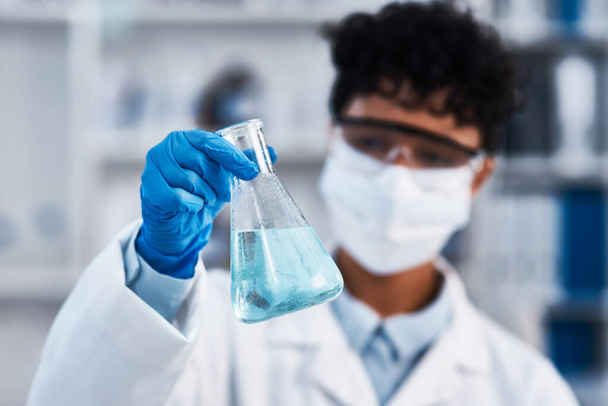 Esta sustancia tiene muchas propiedades únicas. Primer plano de un joven científico sosteniendo un vaso de precipitados en un laboratorio - Foto, imagen