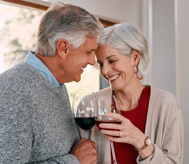 Love is like wine, it just gets better with age. a happy mature couple having red wine together during a relaxing day at home - Fotografie, Obrázek