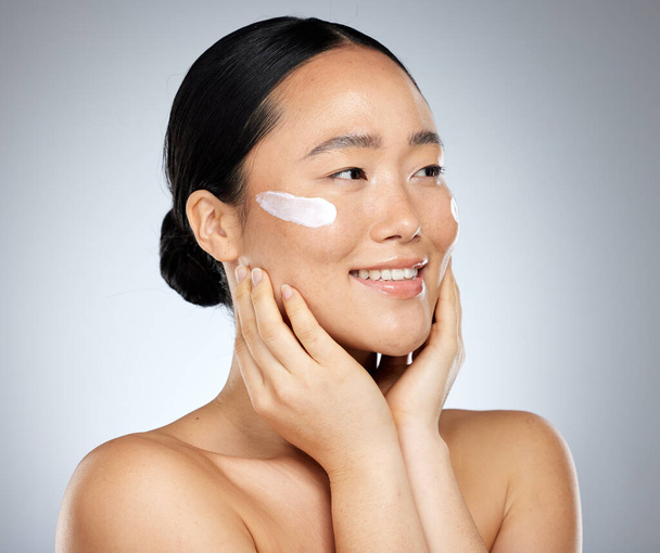 Asian woman, skincare cream and face makeup, sunscreen beauty product and luxury cosmetics wellness on studio background. Happy Japanese model, facial spf lotion and natural aesthetic dermatology. - Foto, Bild