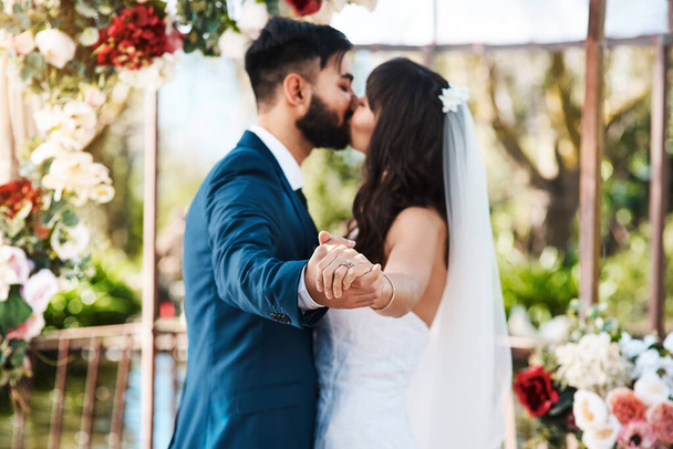 They chose to spend their forever together. an unrecognizable newlywed couple kissing while holding hands on their wedding day - Zdjęcie, obraz
