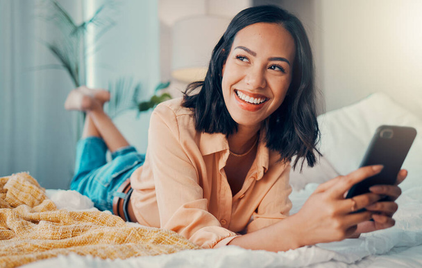 Happy woman, funny social media phone and thinking of online dating profile notification in bedroom in Spain. Young smile female relax at home, smartphone connection and 5g mobile network technology. - Foto, immagini