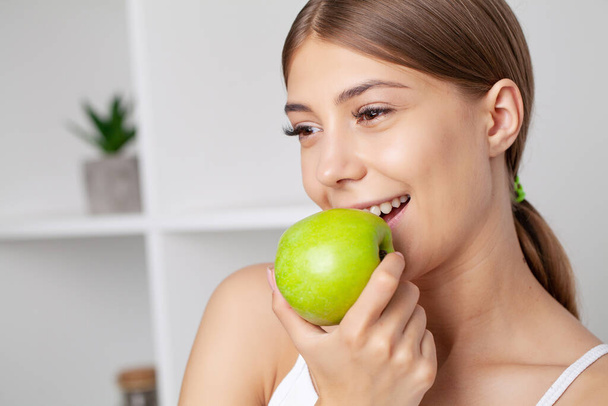 Beautiful Young Girl With White Teeth Holding Hands Of Fresh Green Apple - Fotografie, Obrázek