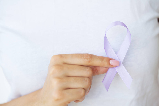 Mujer mano sosteniendo lazo de cinta púrpura, lupus LSE o alzheimer símbolo de conciencia. - Foto, Imagen