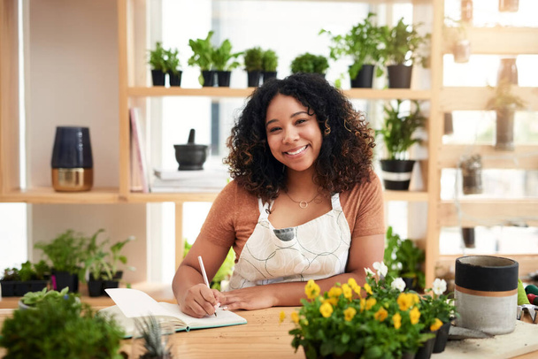What can I get for you today. Cropped portrait of an attractive young female botanist making notes while working in her florist - Foto, Imagem