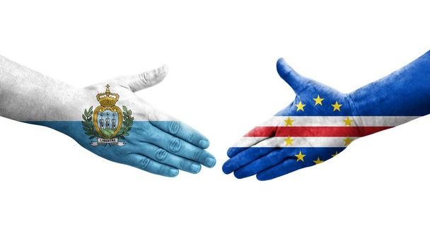 Händedruck zwischen kapverdischen und San Marino-Flaggen, auf Hände gemalt, isoliertes transparentes Bild. - Foto, Bild